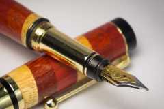 Fountain pen turned by Mike Feeney composed of Yellow Heart, Red Heart, and Padauk woods.